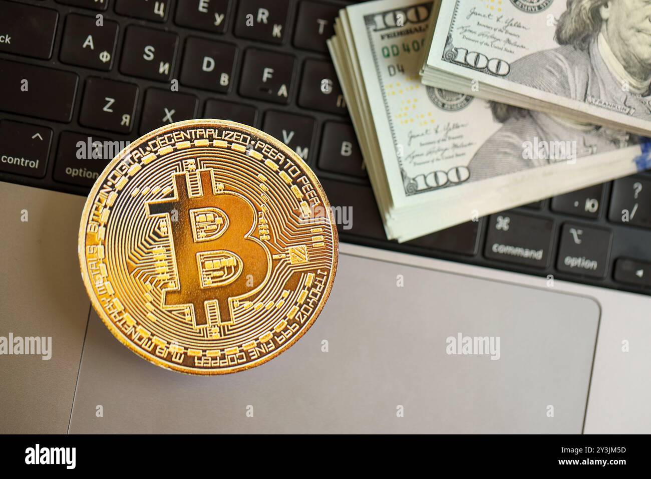 Bitcoin on a laptop keyboard and hundred-dollar bills in blue light.  Payment in cryptocurrency in the metaverse. Selective focus Stock Photo -  Alamy