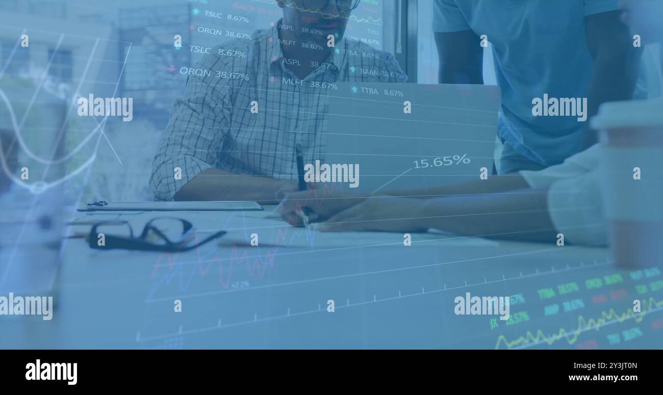 Image of financial data processing over diverse business people using laptop Stock Photo