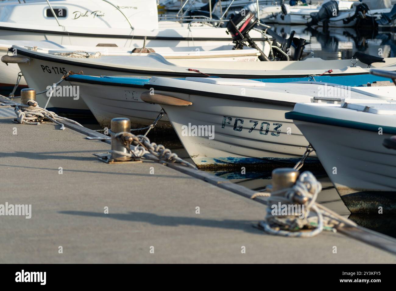 Boat bows in row moored at concrete dock Stock Photo - Alamy