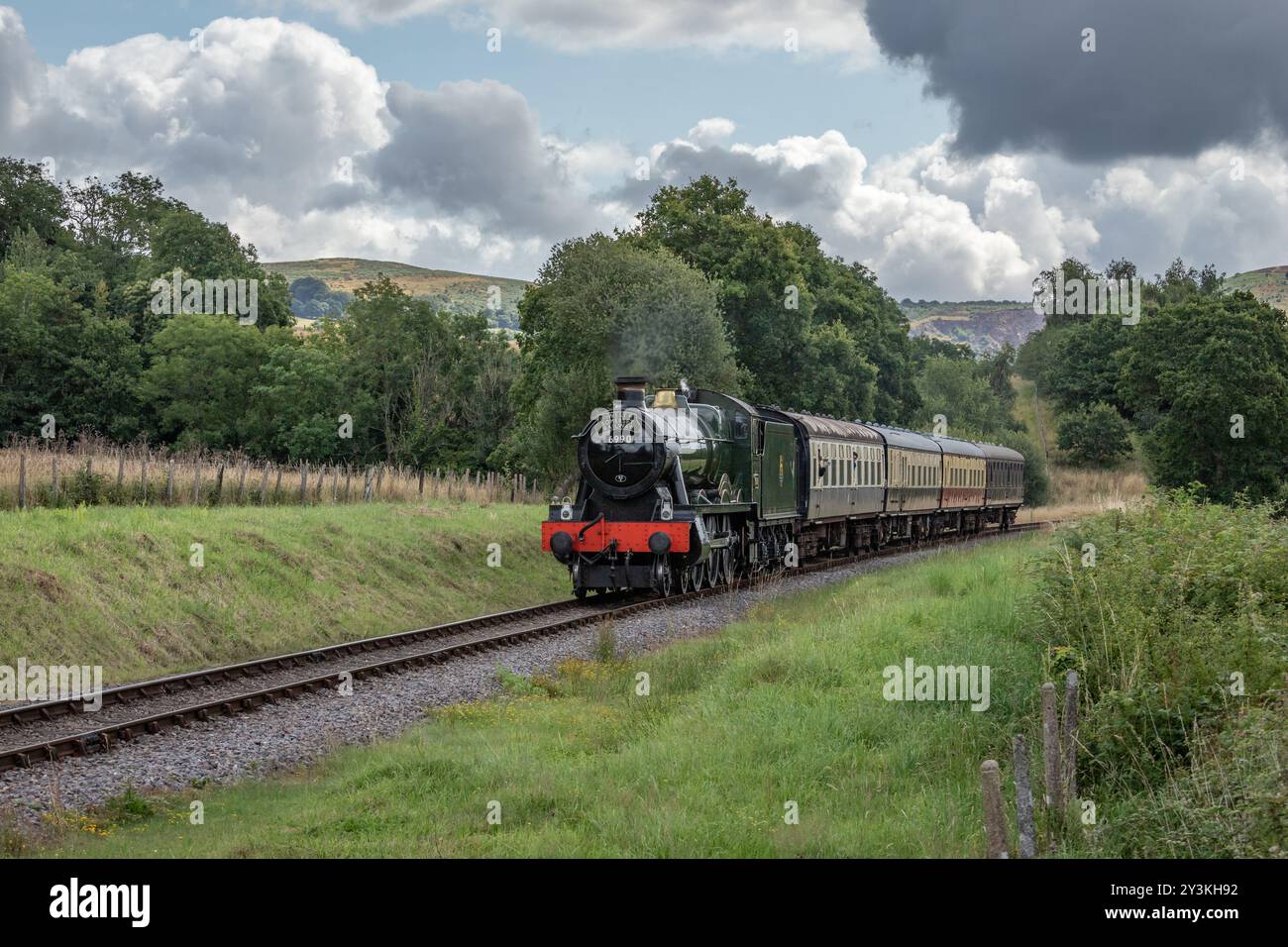 Visiting steam locomotive BR (W) 6959 Hall Class 6990 Witherslack Hall approaches Leigh Wood Crossing on the West Somerset Railway Stock Photo