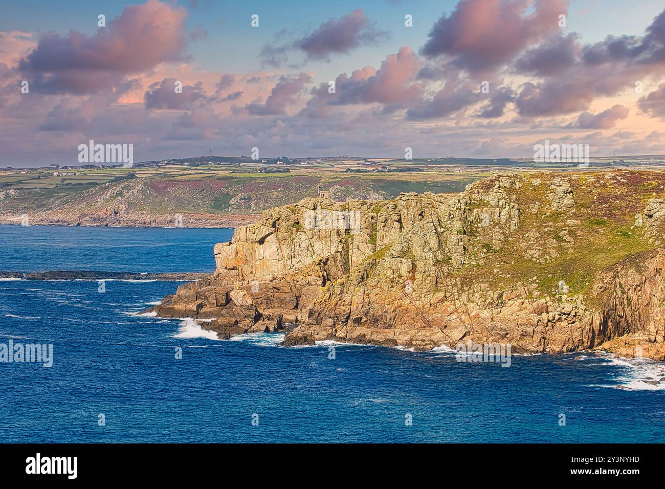 A scenic coastal view featuring rugged cliffs and vibrant blue waters ...