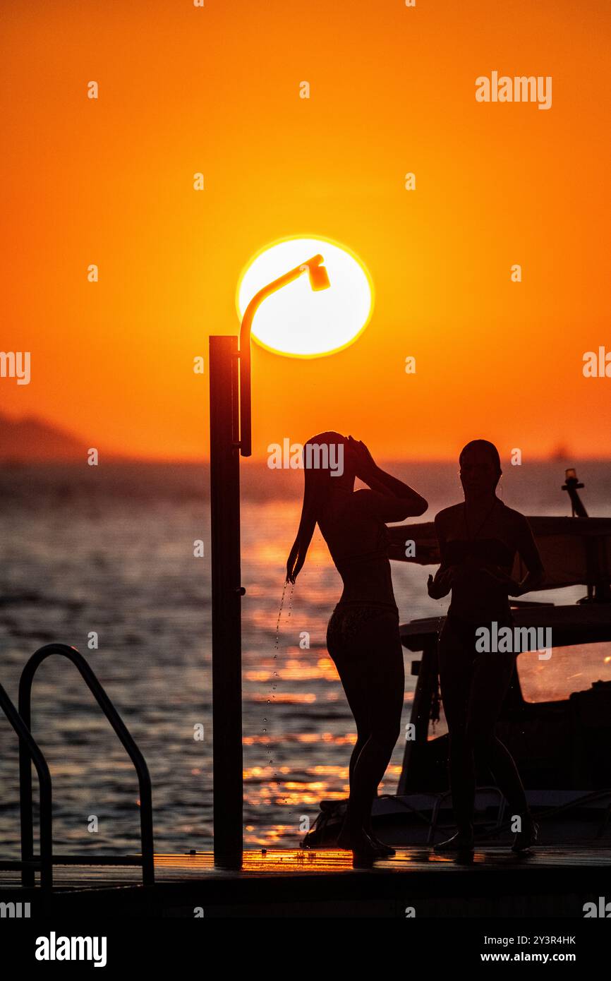 A beautiful girl showering as the sun goes down on holiday in Croatia Stock Photo