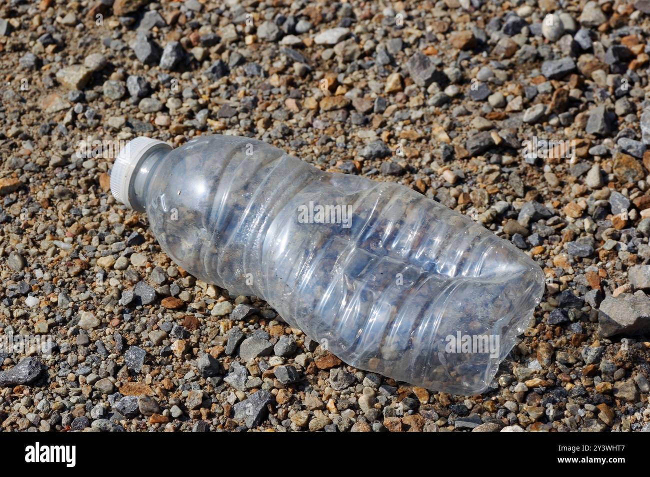 Discarded empty plastic water bottle laying on the ground. Quebec,Canada Stock Photo