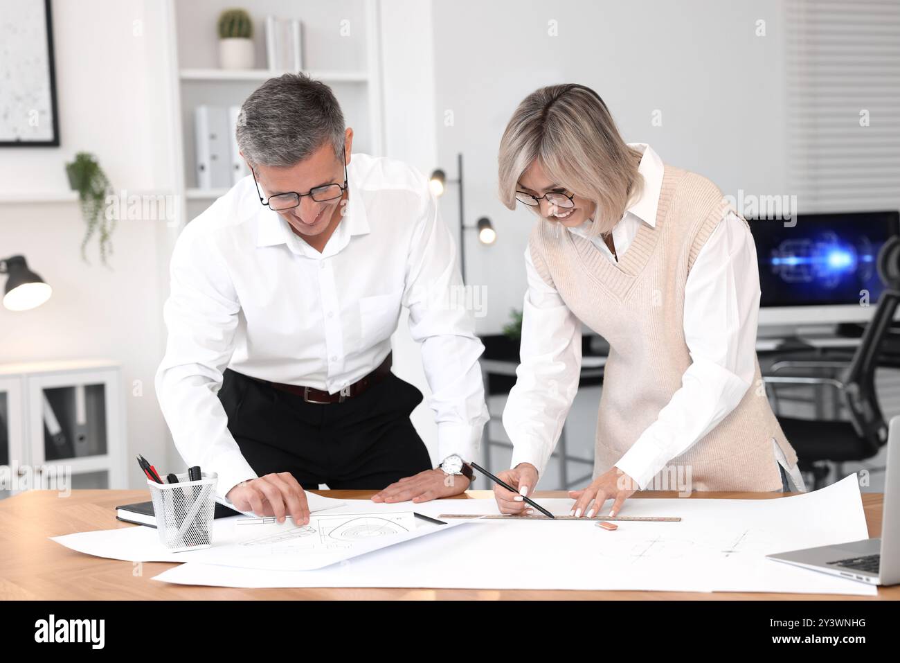 Architects making engineering drawing at wooden table in office Stock Photo