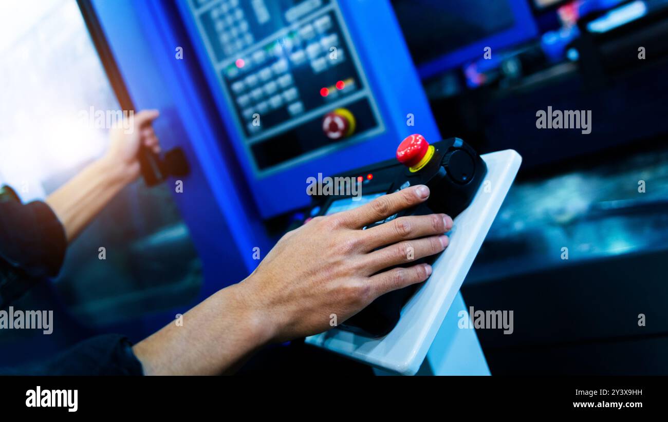 Worker hand controling cnc machine at workshop Stock Photo