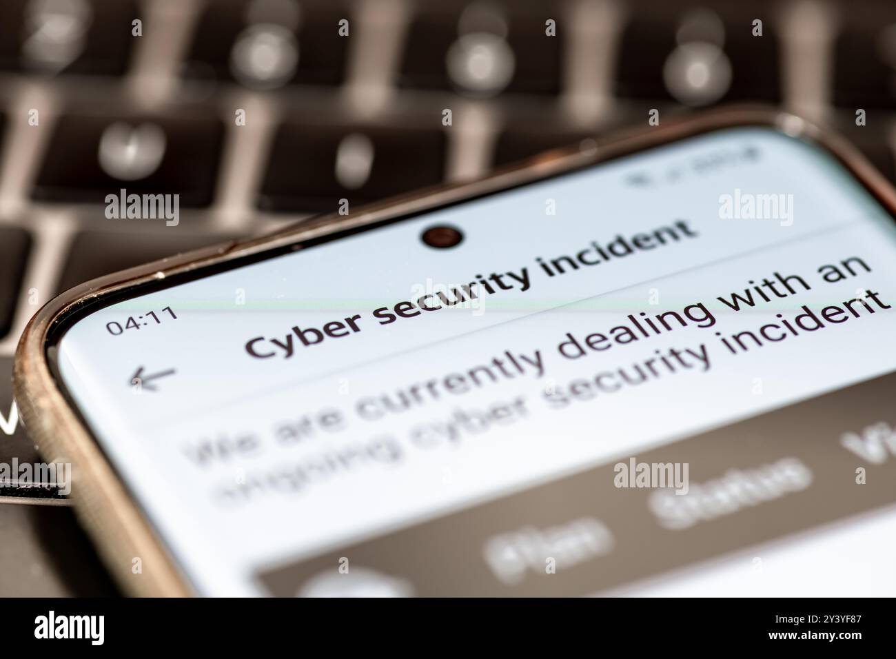 Close up of a message on a mobile phone from a company informing its clients of an ongoing cyber security incident. Stock Photo
