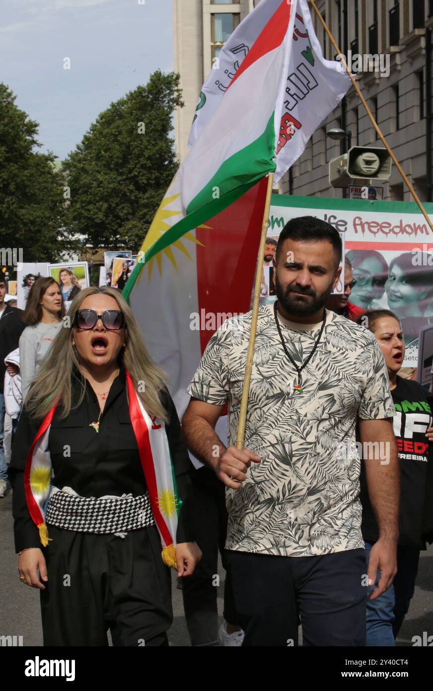 September 15, 2024, London, England, UK: Protesters march across London, one holding an Iranian flag. Protesters gather together to demonstrate on the 2-year -anniversary of the death of Mahsa Amini ( 16 September 2002) and celebrate the Women, Life, Freedom movement. They are calling for theBritish government to put the Islamic regime in Iran to be put on the proscribed list of terrorist organisations and for executions in Iran to stop. Iranian Mahsa Amini fell into a coma and died after being arrested in Tehran by the morality police, for allegedly violating the countryâ€™s hijab rules. (Cre Stock Photo