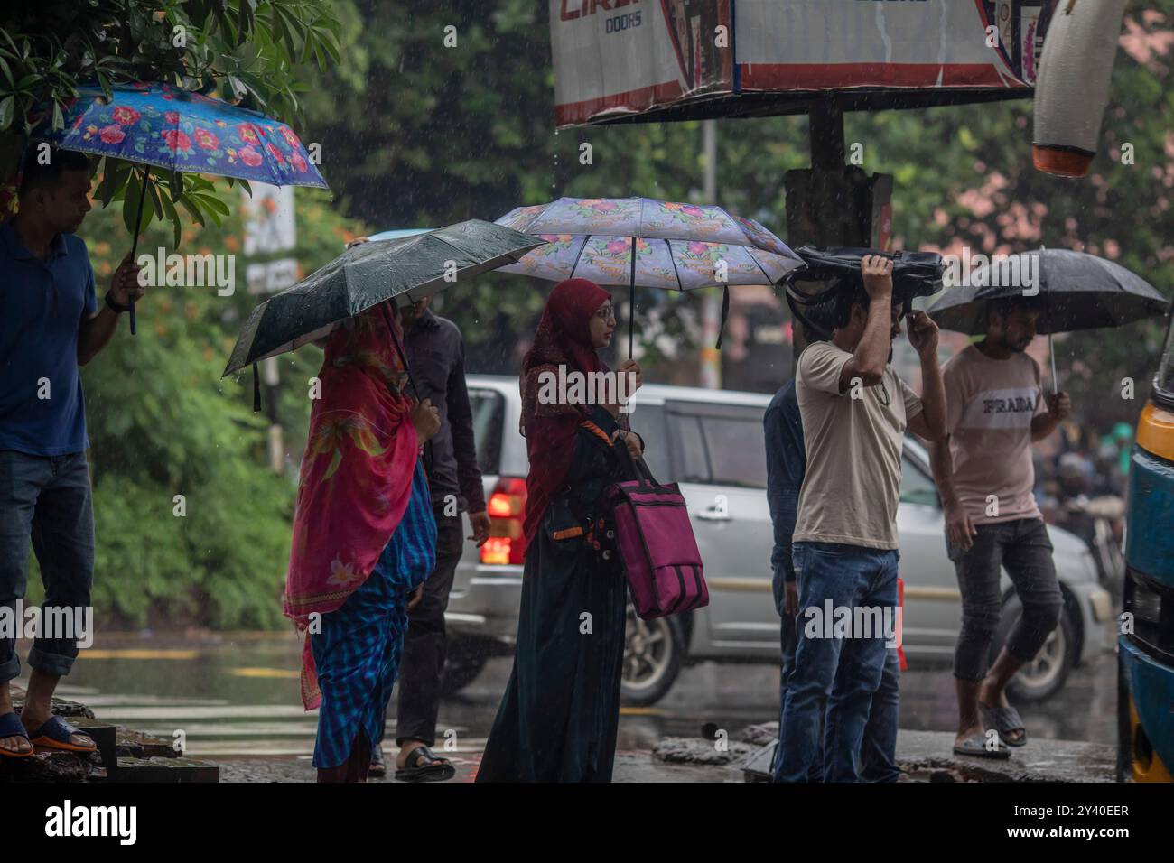 A group of people seen holding umbrellas while crossing the road on a ...
