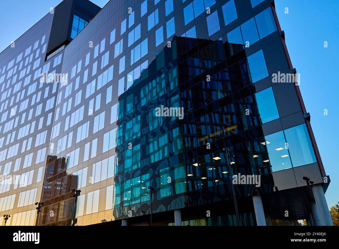 Modern glass office building reflecting city skyline in windows at ...