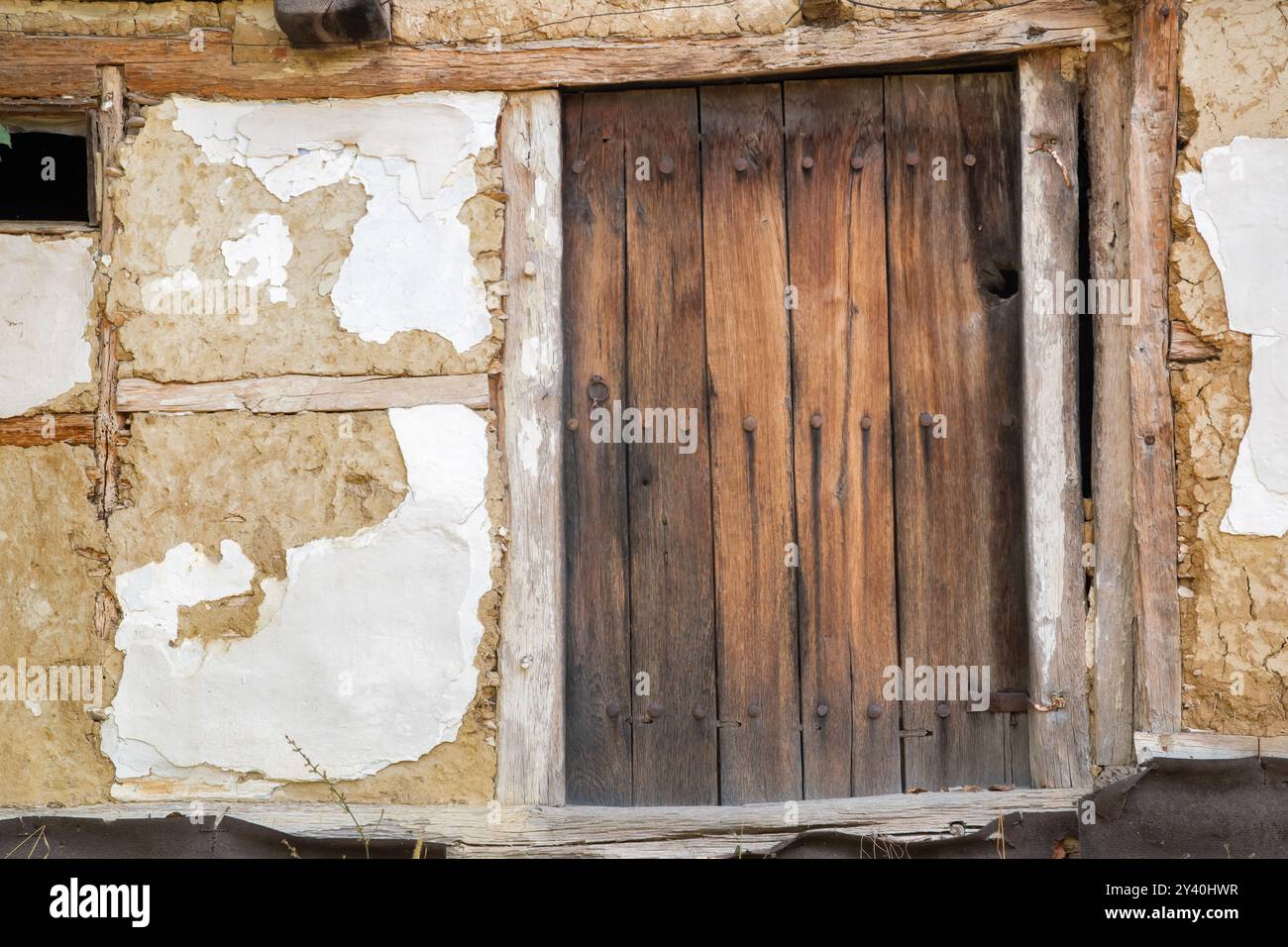 Old wooden door on the wall of an old house in the village Stock Photo ...