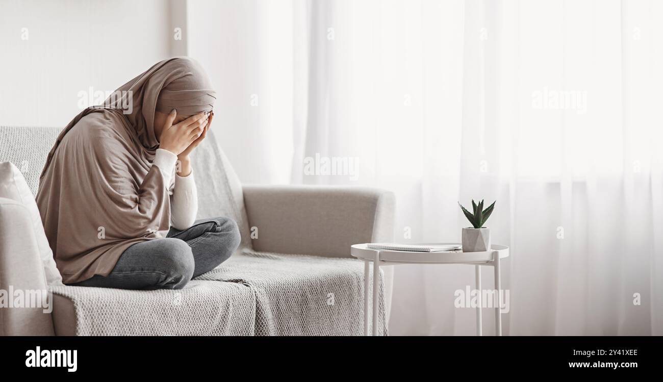 Depressed arabic girl in hijab crying on sofa at home Stock Photo - Alamy
