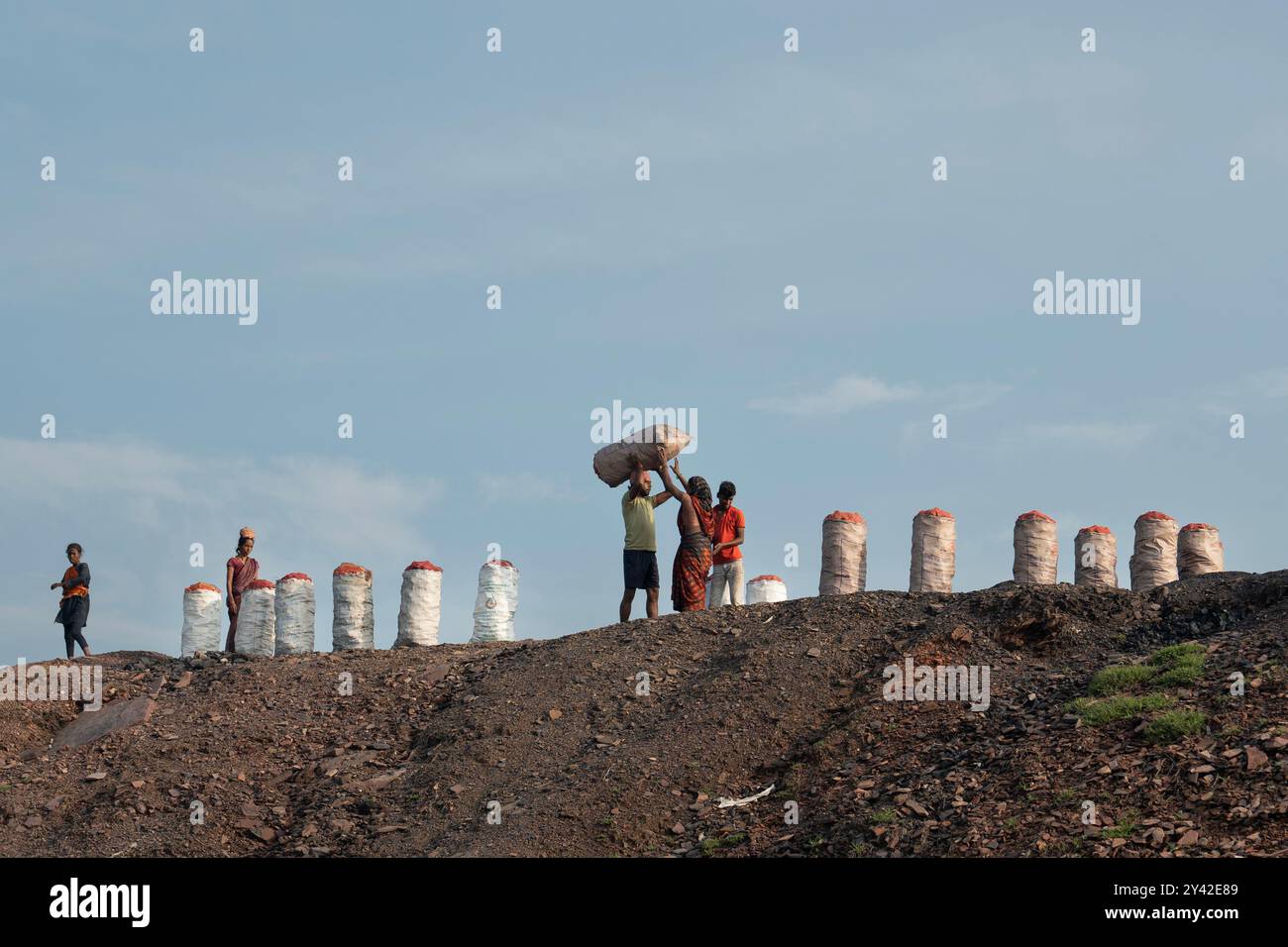 workers-carry-sacks-of-coal-near-an-open-cast-mine-on-the-outskirts-of