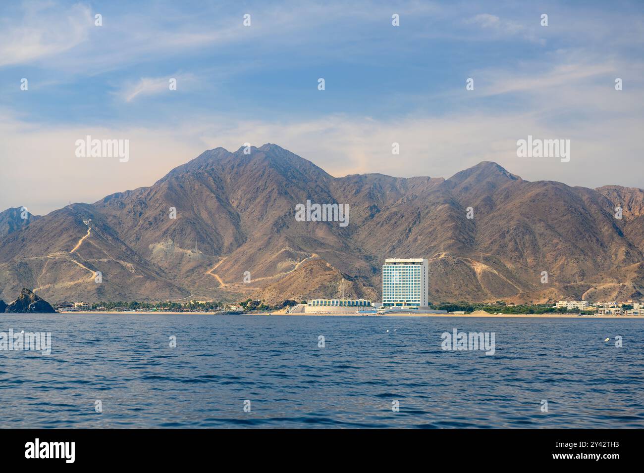 Sea view of the mountains and hotels on the coast of the Gulf of Oman on the Arabian Peninsula near the city of Fujairah in the United Arab Emirates Stock Photo