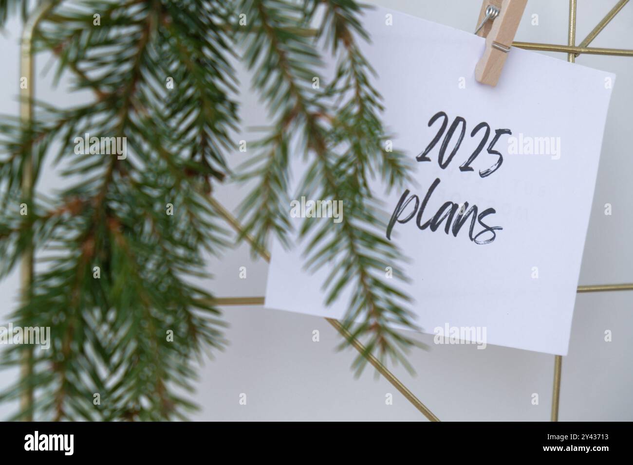 2025 PLANS text on white paper note on vision board with Christmas decor. New year aims resolutions. New me you concept visualizing dreams  Stock Photo