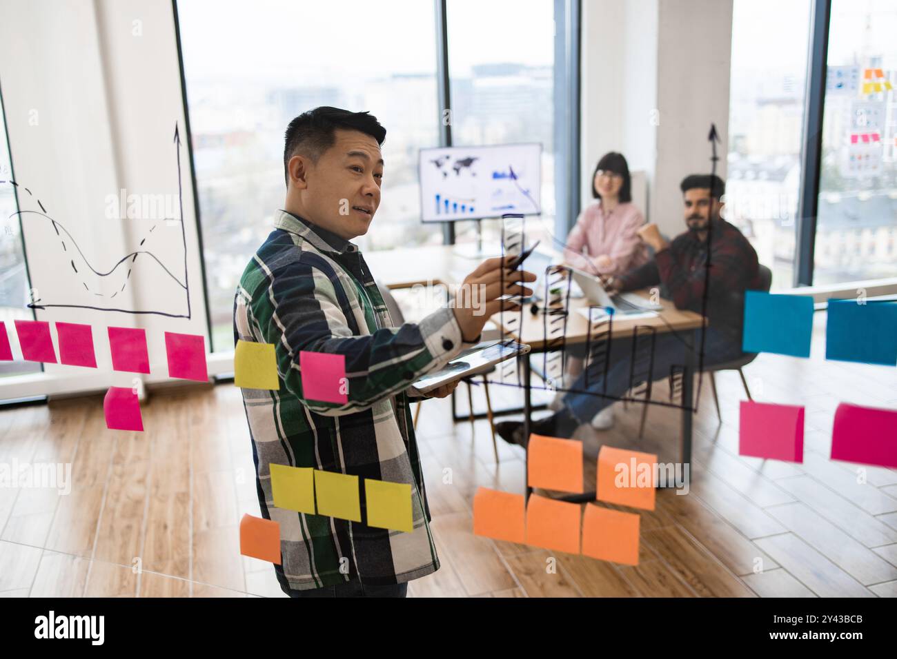 Team brainstorming session with sticky notes and charts Stock Photo - Alamy