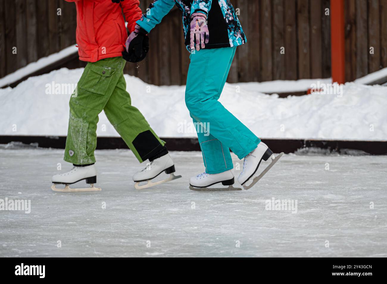 Riga, Latvia - December 29, 2021: Two children skate in winter clothes ...