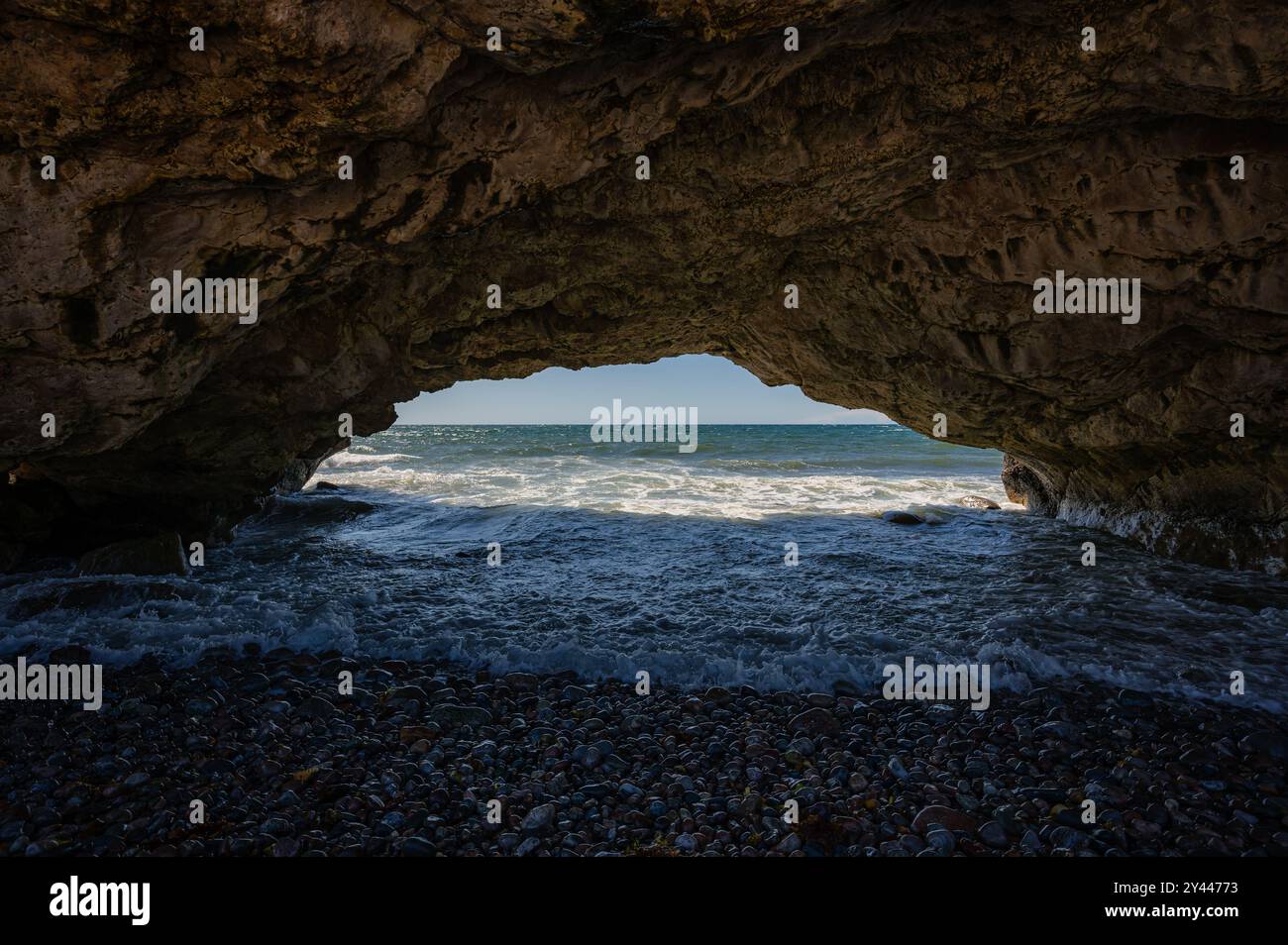 View under natural rock arch on beach in Newfoundland, Canada Stock ...