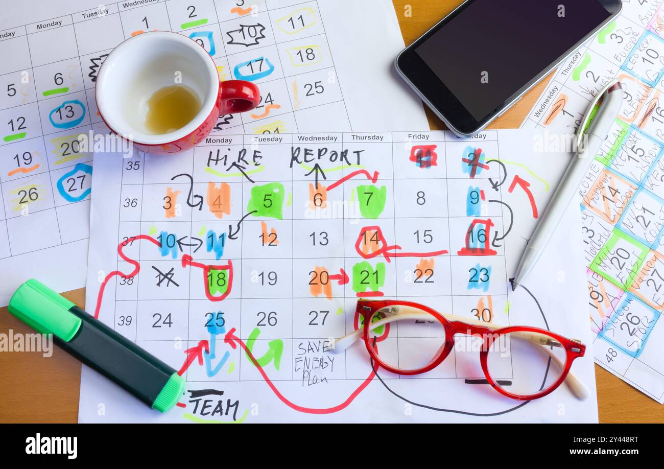 Calendar with business appointments pens coffee cup and spectacles