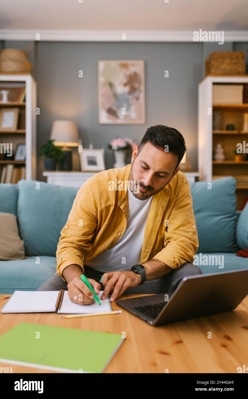 Digital nomad working from home with a laptop and notes Stock Photo