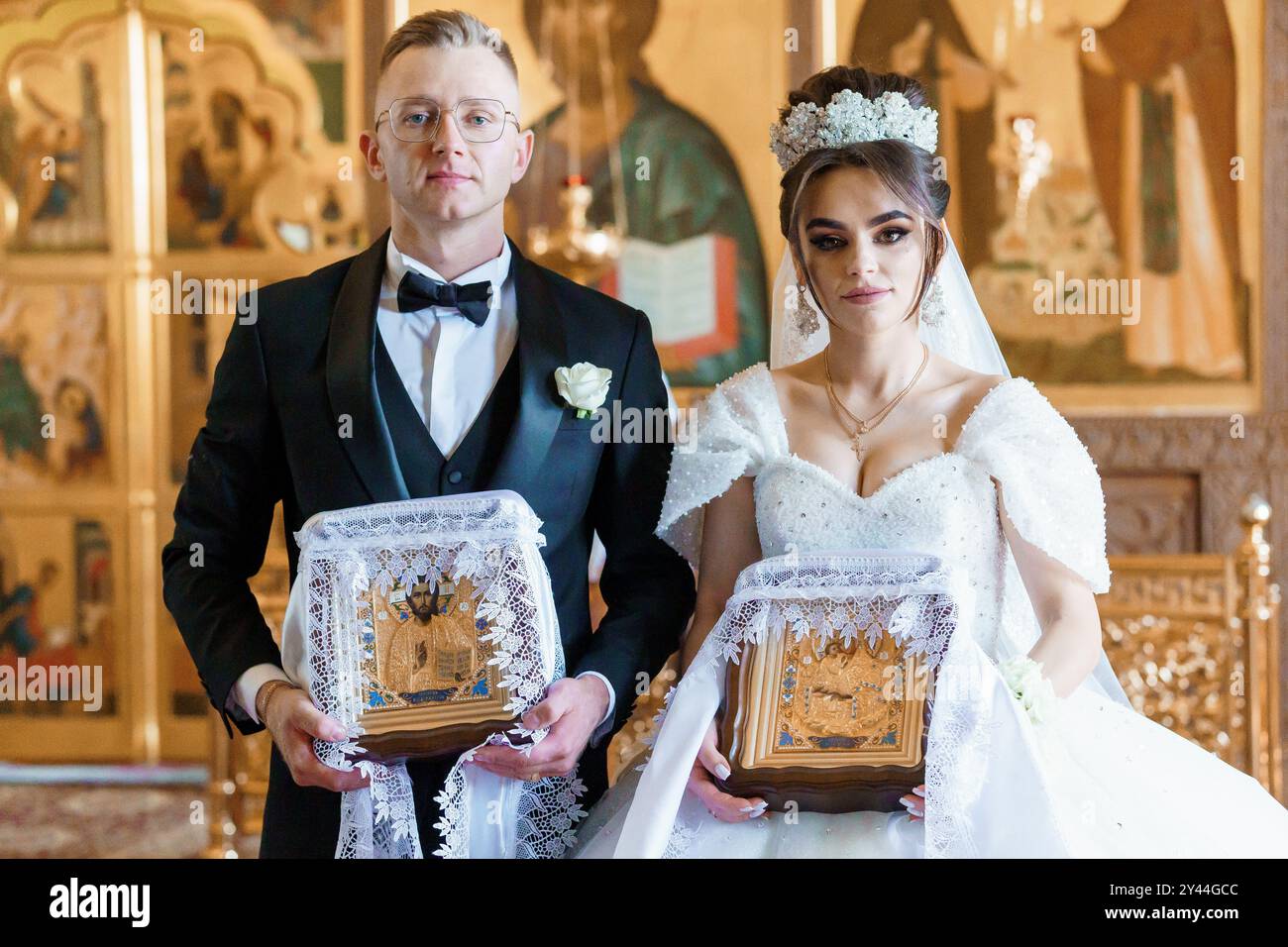 Elegant Bride and Groom Holding Ornate Religious Icons in Traditional ...