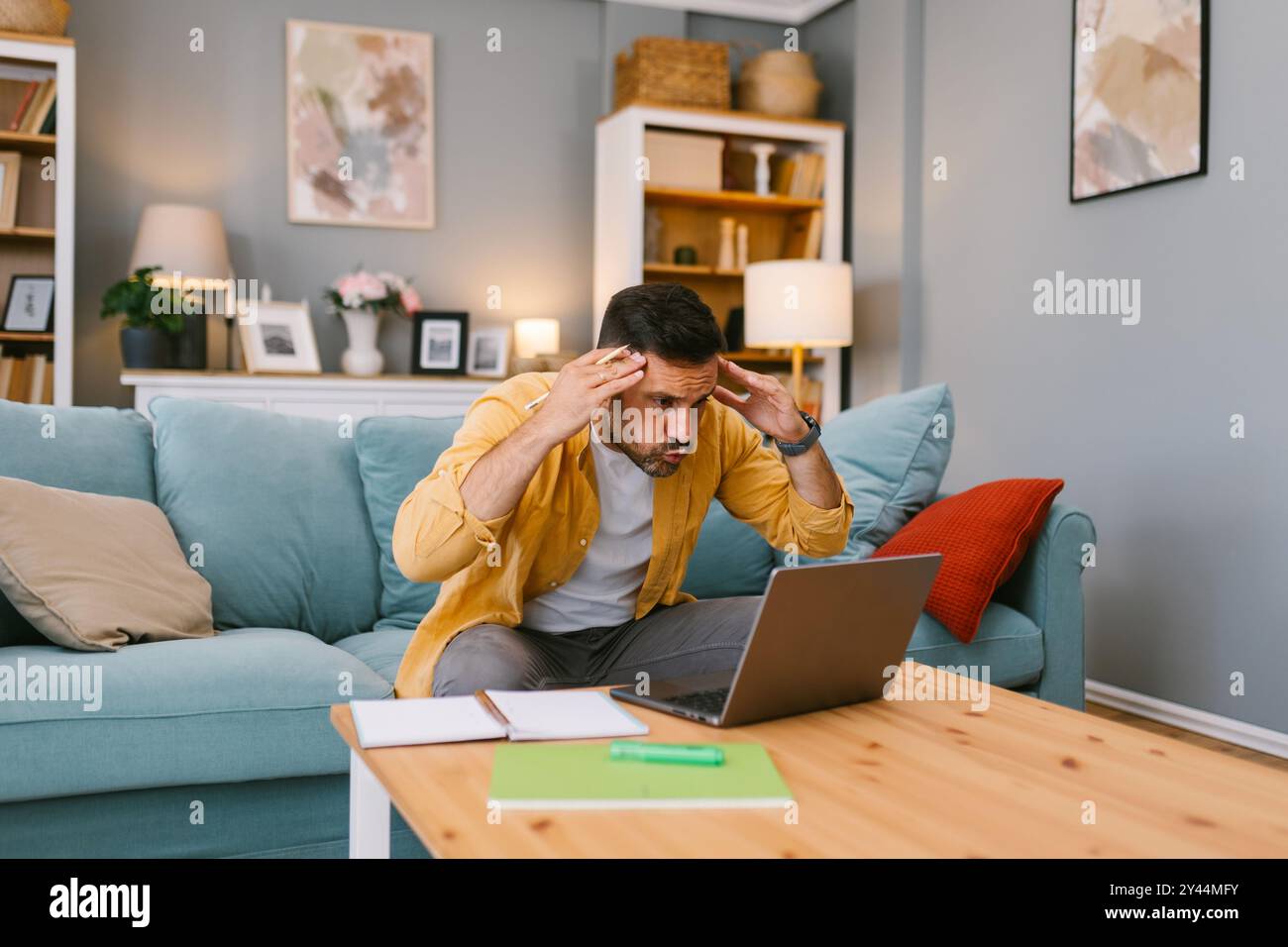 Stressed man dealing with a problem on his laptop Stock Photo