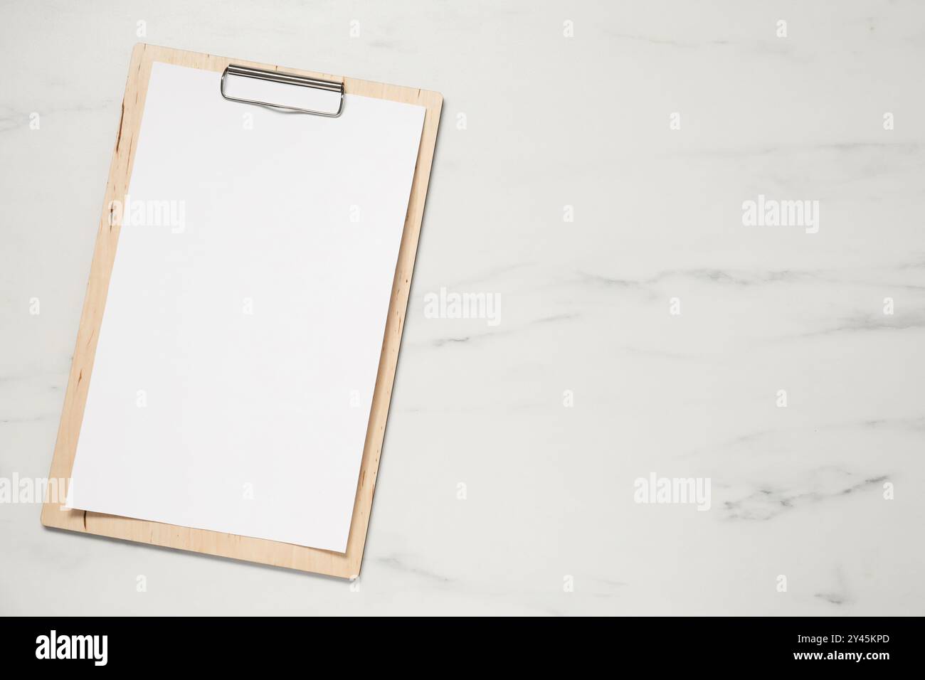 Clipboard with empty paper on white marble table, top view. Mockup for design Stock Photo