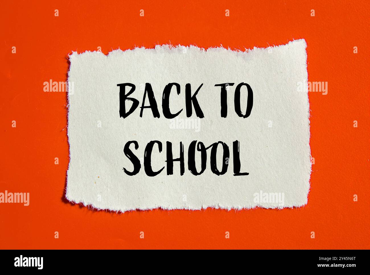 Back to school message written on ripped torn paper piece with orange ...