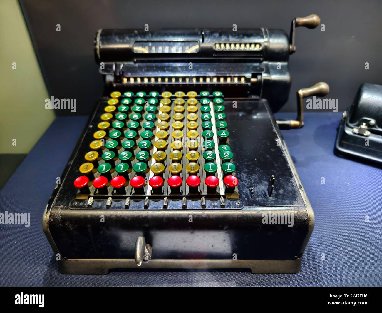 An old fashioned adding machine features a drawer located underneath it Stock Photo