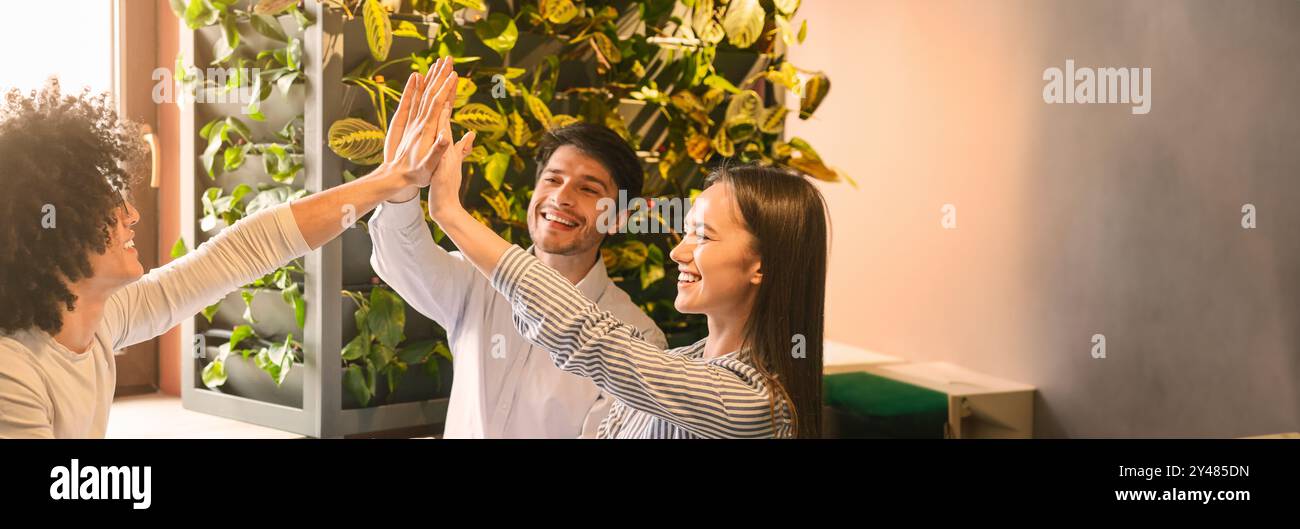Excited multiethnic team giving each other high five Stock Photo