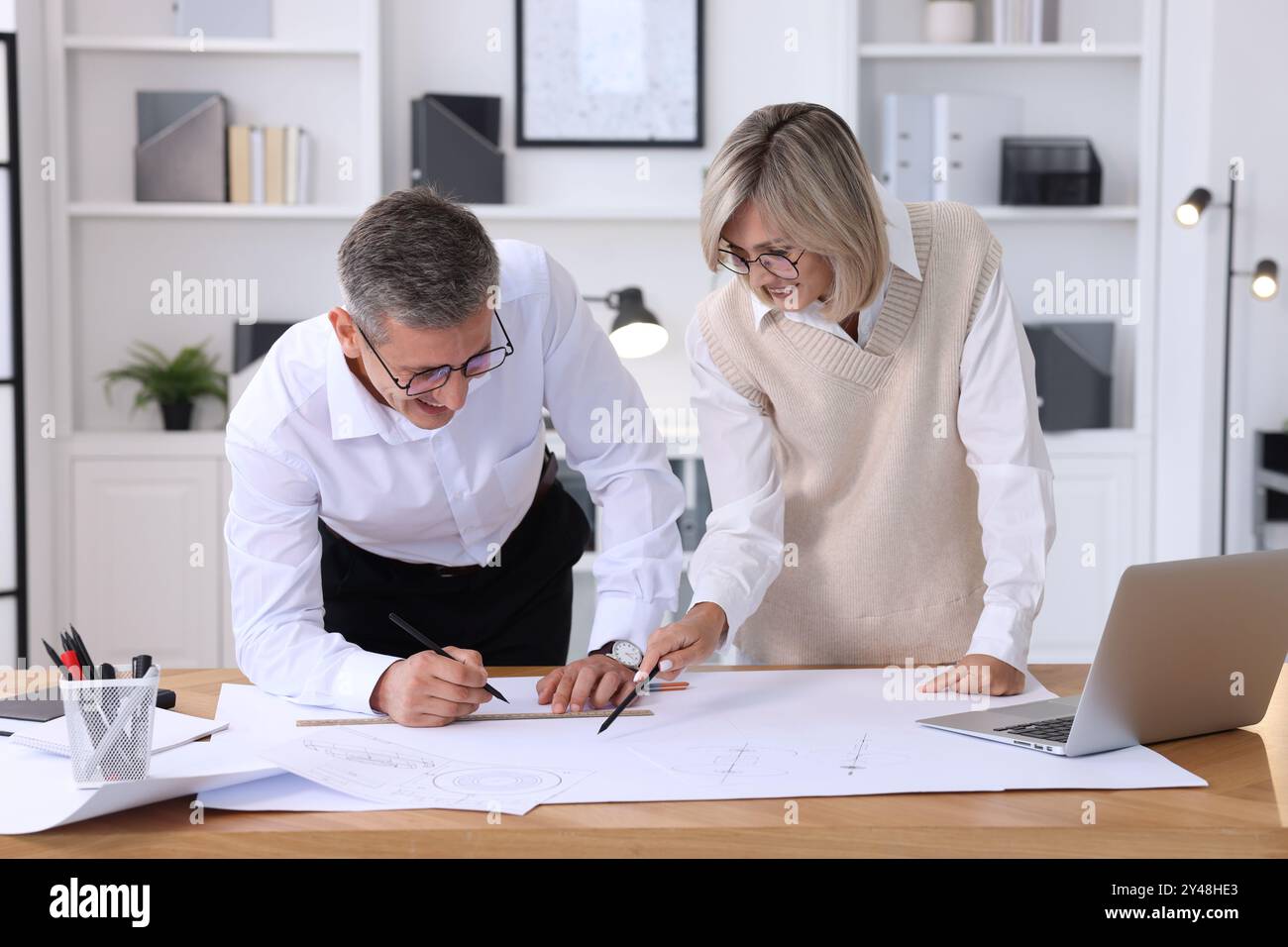 Architects making engineering drawing at wooden table in office Stock Photo