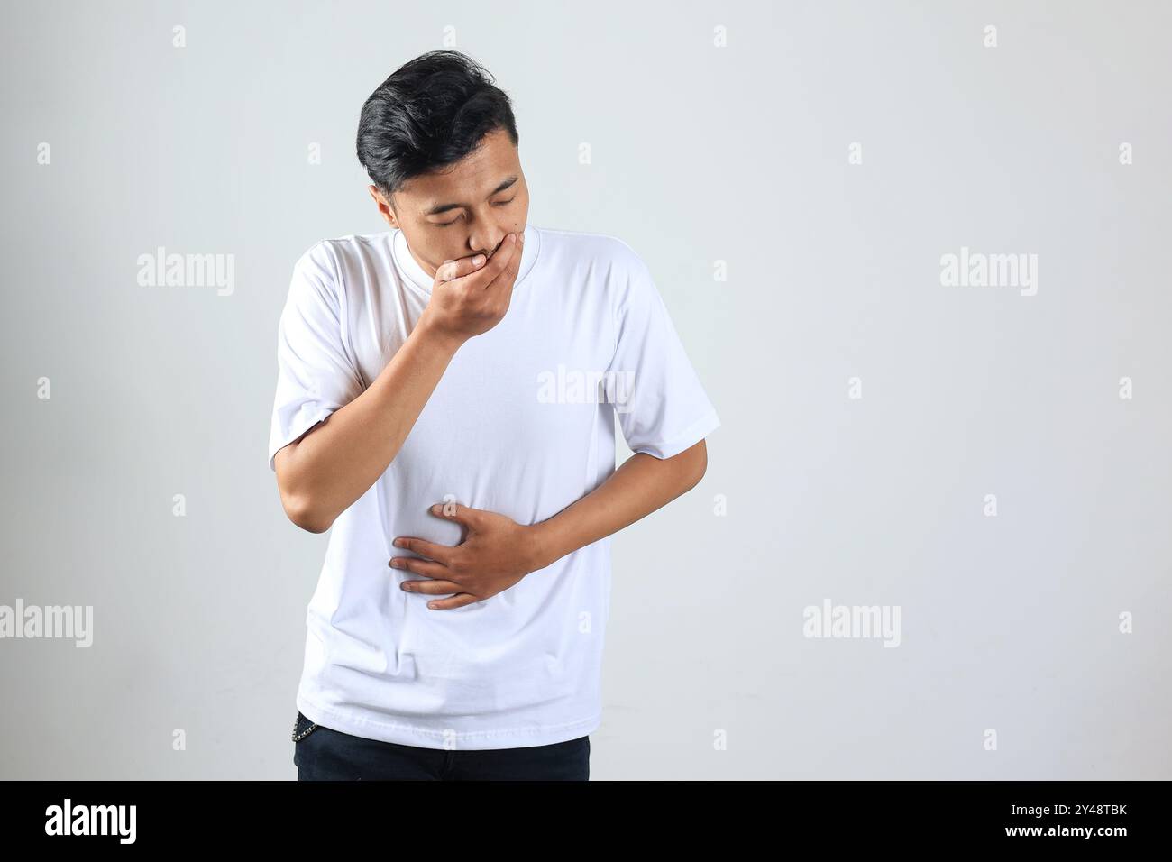 Asian Man Putting Hands on His Belly or Stomach Ache on White Background. Health Medical Concept Stock Photo