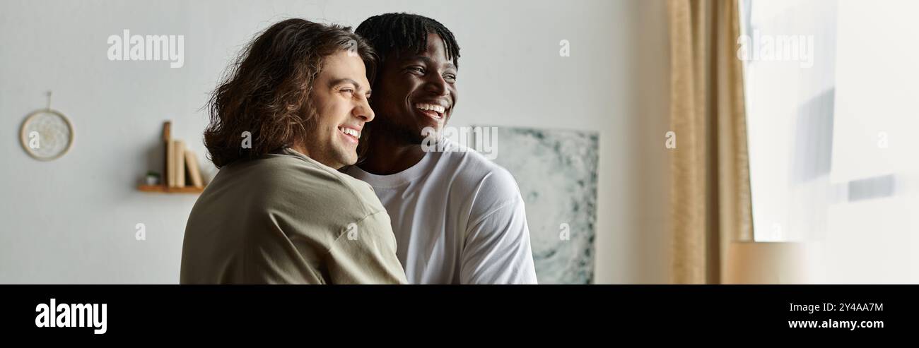 Two joyful men share a heartfelt embrace, smiling warmly in their inviting living space. Stock Photo