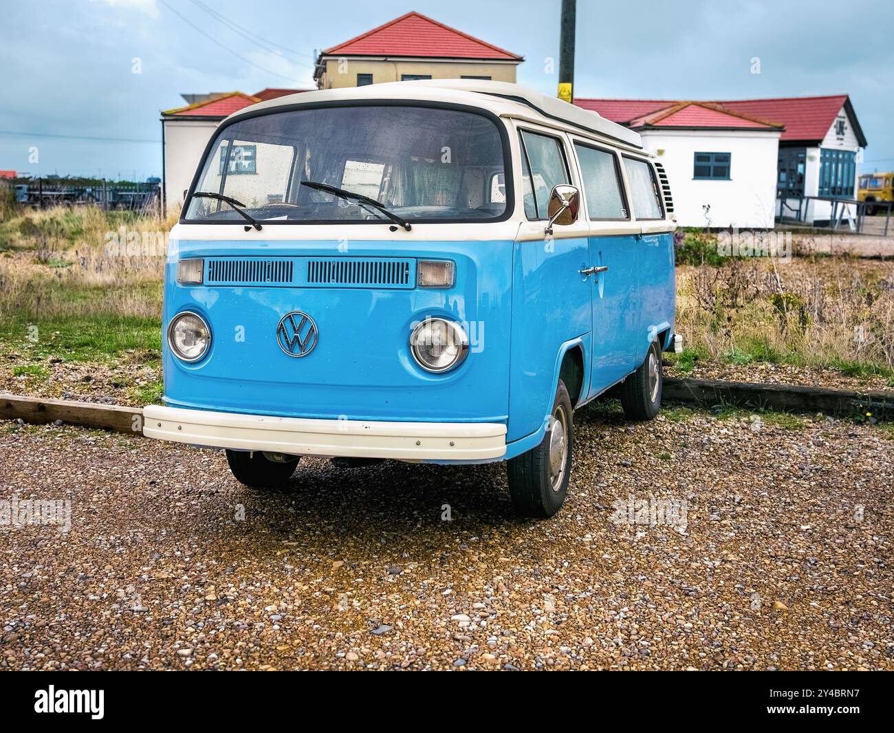 A classic blue Volkswagen Campervan is parked at Dungeness, just ...