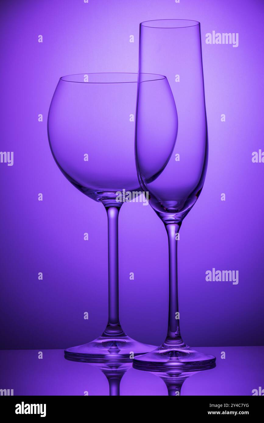 Two empty wineglasses on a purple background Stock Photo