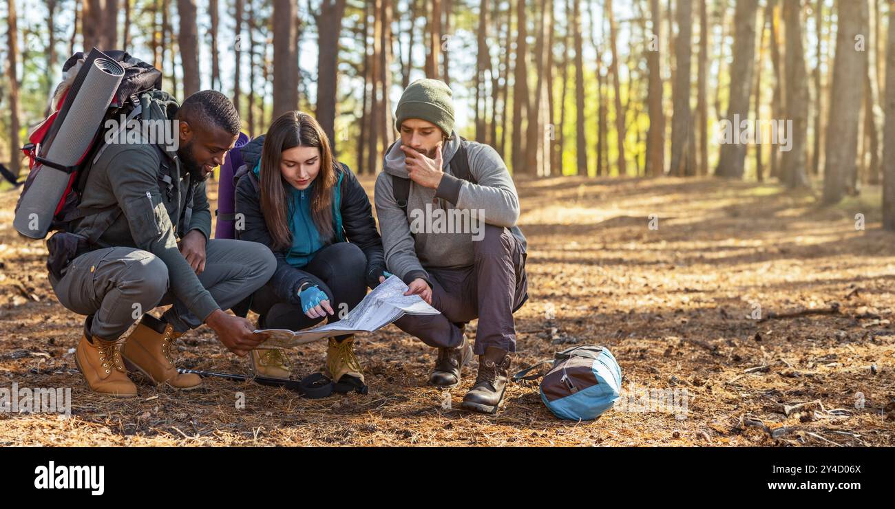 Lost Using. Map Lost backpackers looking for location, using map Stock Photo - Alamy