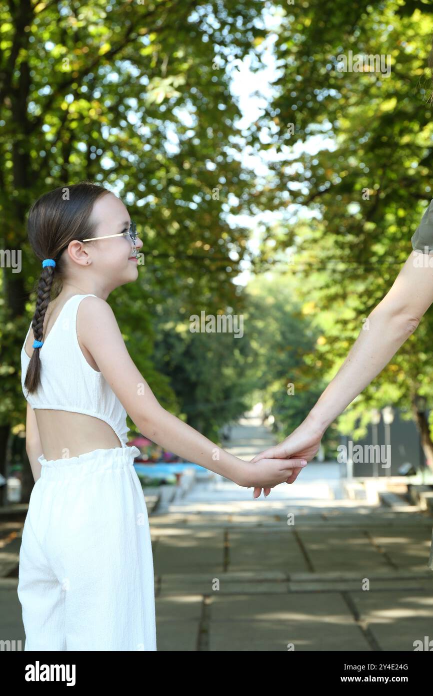 Little girl holding hands with mother in park, closeup Stock Photo - Alamy