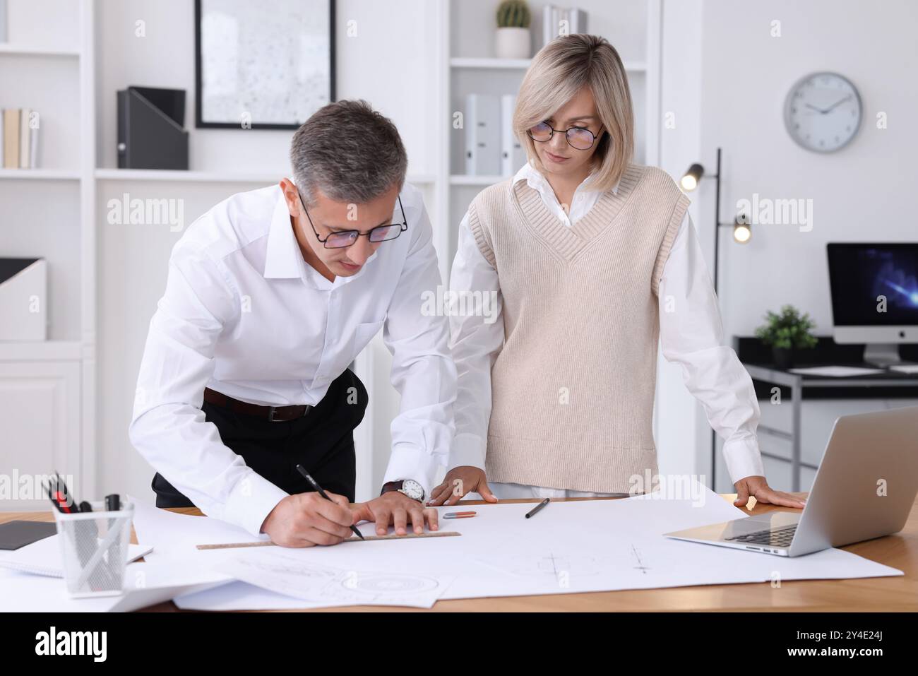 Architects making engineering drawing at wooden table in office Stock Photo