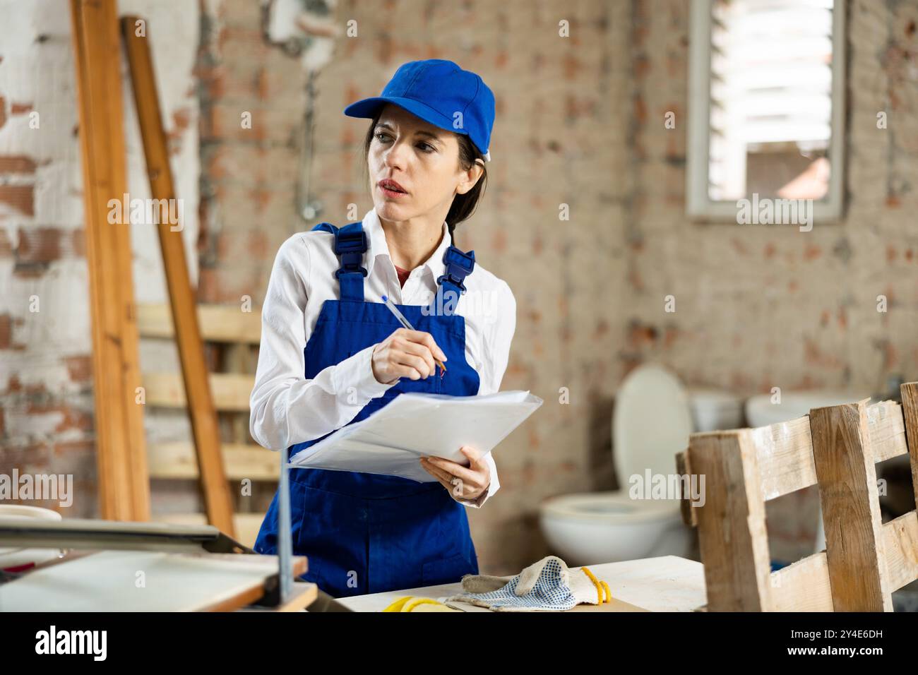 Female contractor taking notes while planning building renovation Stock Photo