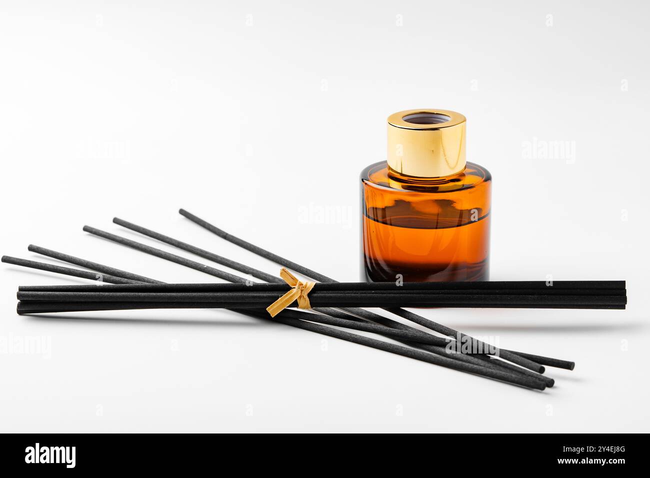 A minimalist display of essential oil and black diffuser sticks on a ...