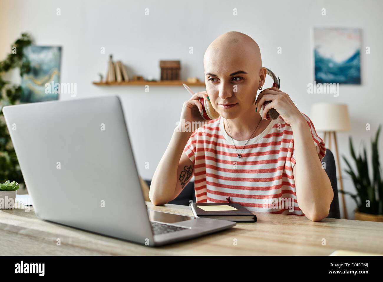 A confident woman wears headphones while focused on her laptop during a ...