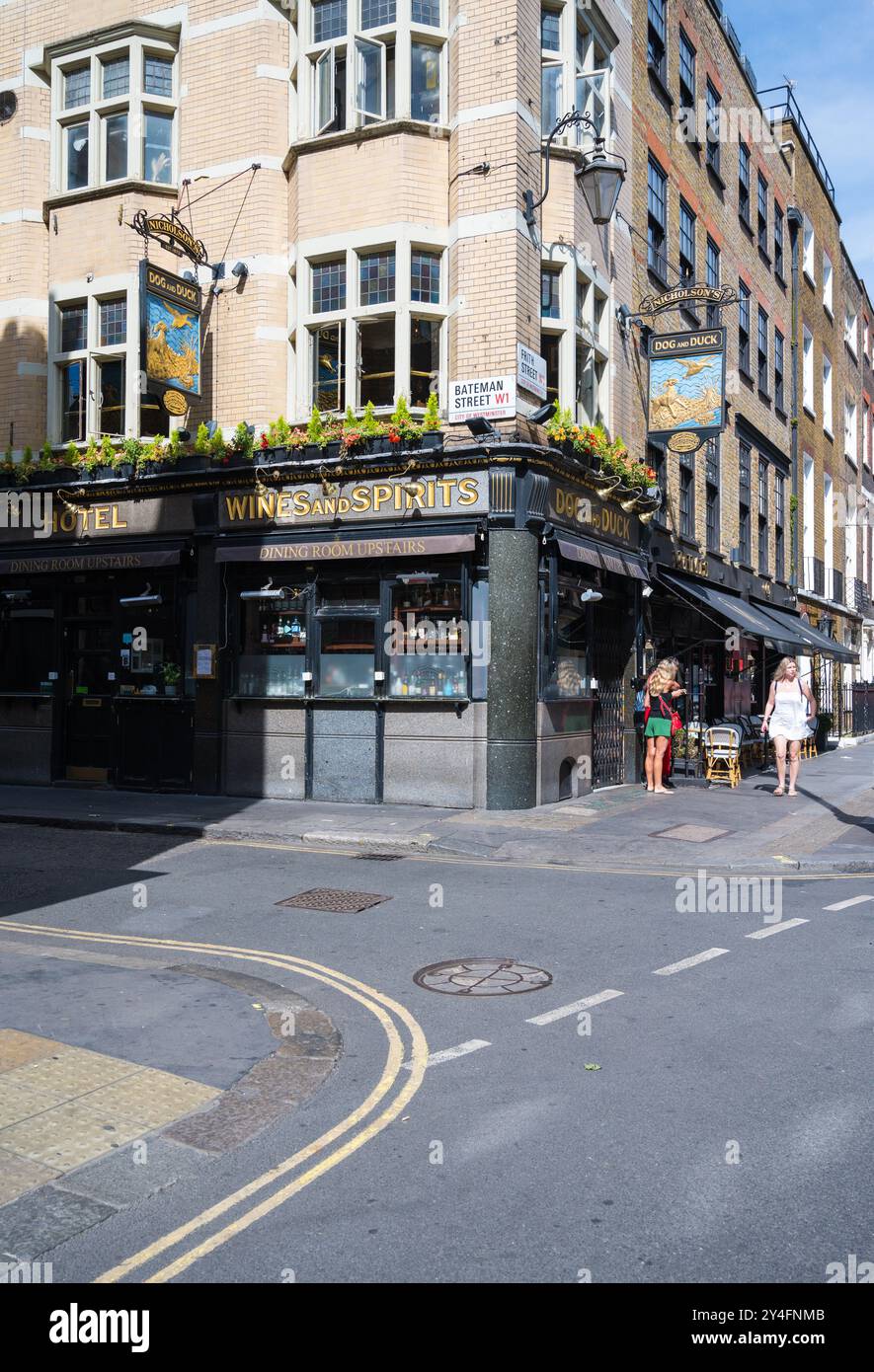 Two young women stand in conversation outside The Dog And