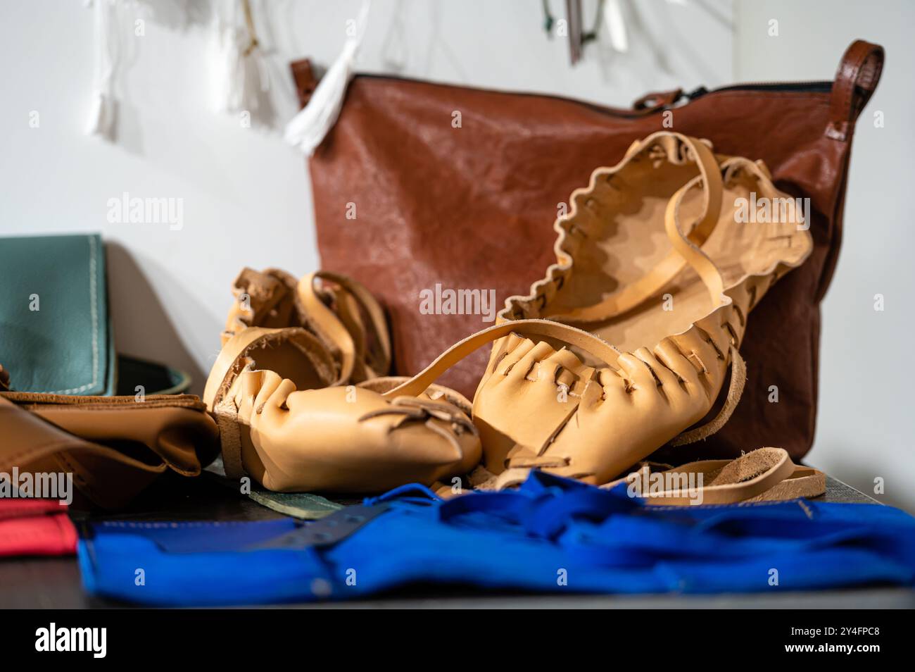 Craftspeople showcase various leather creations including bags and shoes. Stock Photo