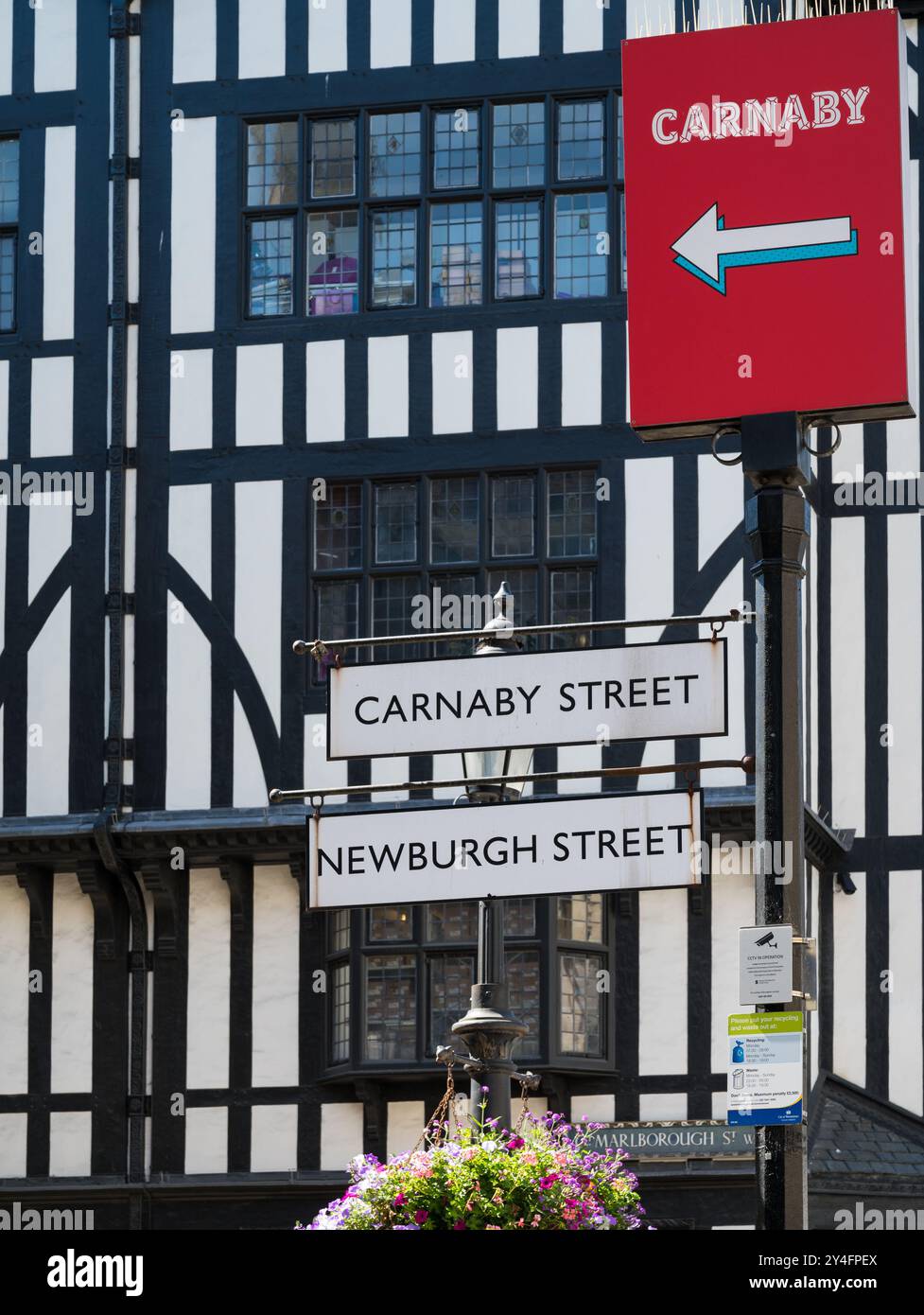 Direction signs for Carnaby Street and Newburgh Street outside Liberty's department store Soho London England UK Stock Photo