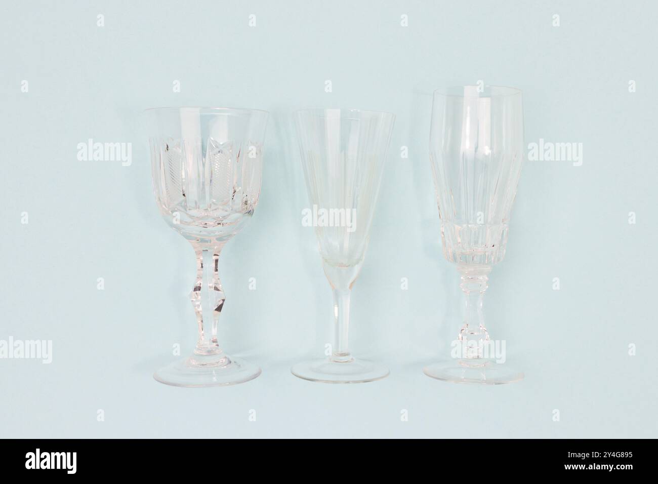 Three vintage crystal glasses on a blue background. Stock Photo
