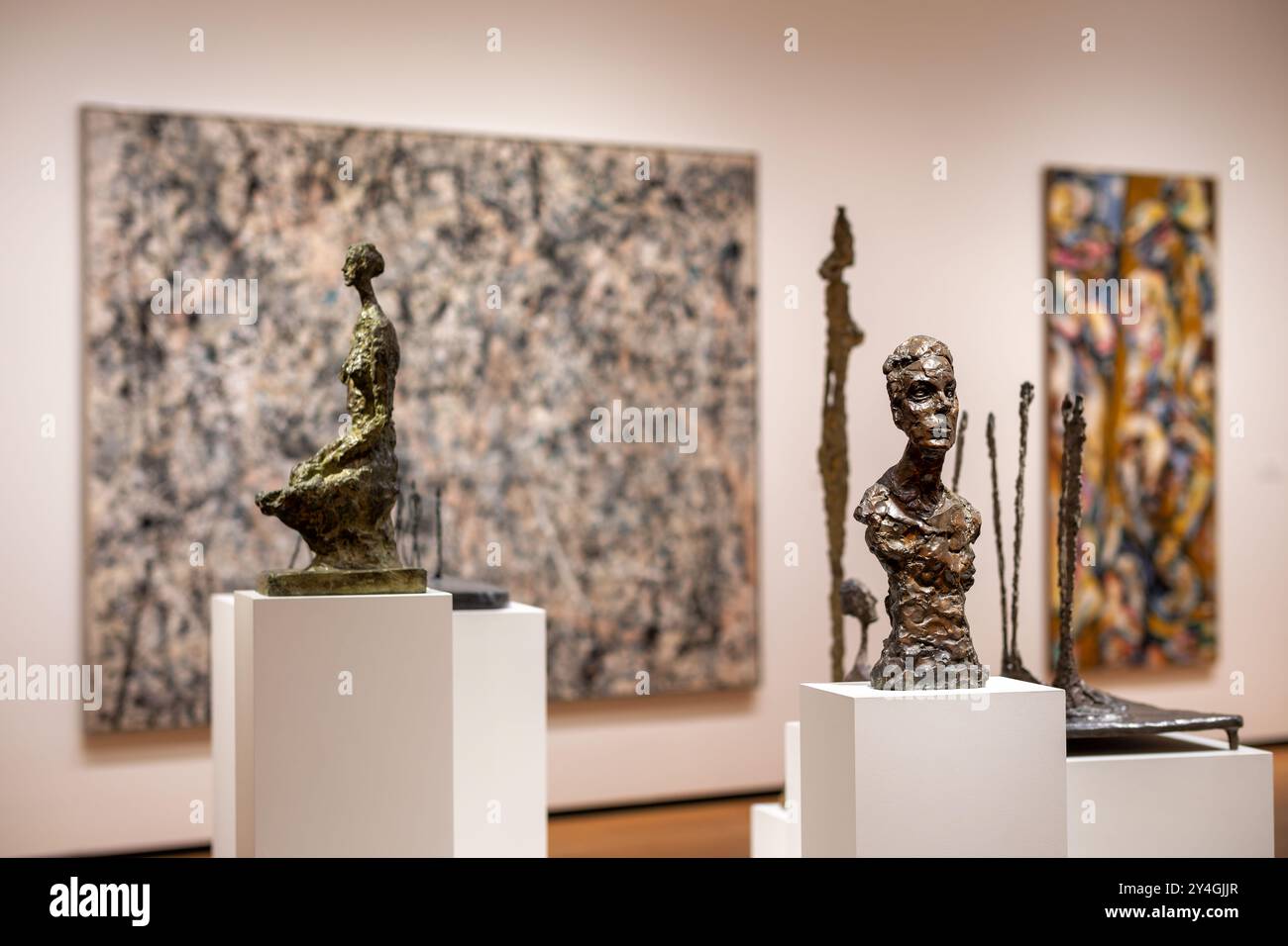 National Gallery Of Art Modern Art Sculptures Washington DC // WASHINGTON DC — Modern art sculptures stand prominently in the foreground of the East Building of the National Gallery of Art, with Jackson Pollock's iconic 'Number 1, 1950 (Lavender Mist)' visible in the background. This dynamic exhibition space showcases the museum's dedication to presenting significant 20th-century artworks, offering visitors a comprehensive view of modern artistic developments. Stock Photo