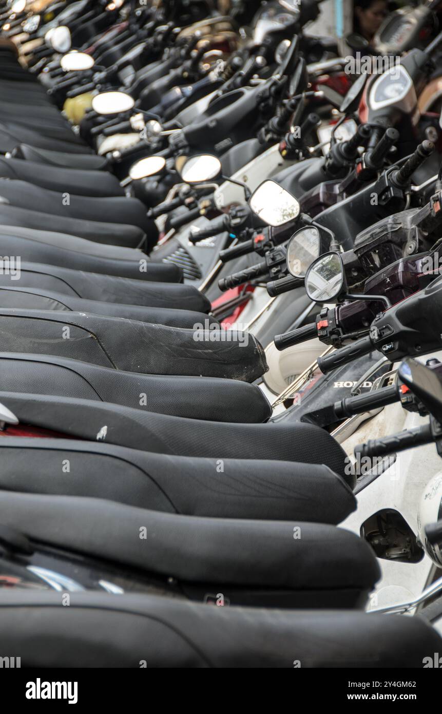 HANOI, Vietnam — A long row of motorbikes and scooters is lined up on the side of a street in the Old Quarter of Hanoi. The scene reflects the city's reliance on two-wheelers for transportation, a common sight in this bustling part of Vietnam. Stock Photo