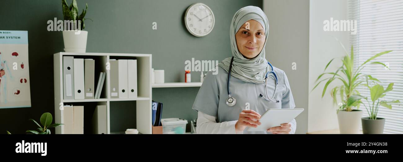 Smiling Female Doctor in Modern Office Holding Tablet Stock Photo