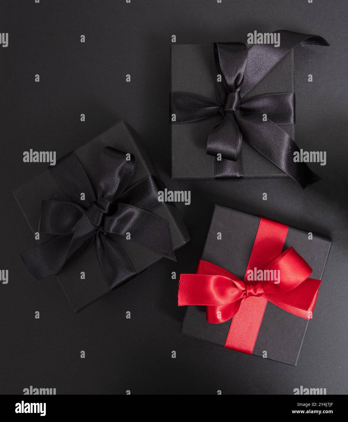 Black Friday Sale. Black gift boxes with ribbon bow isolated on black, top view Stock Photo