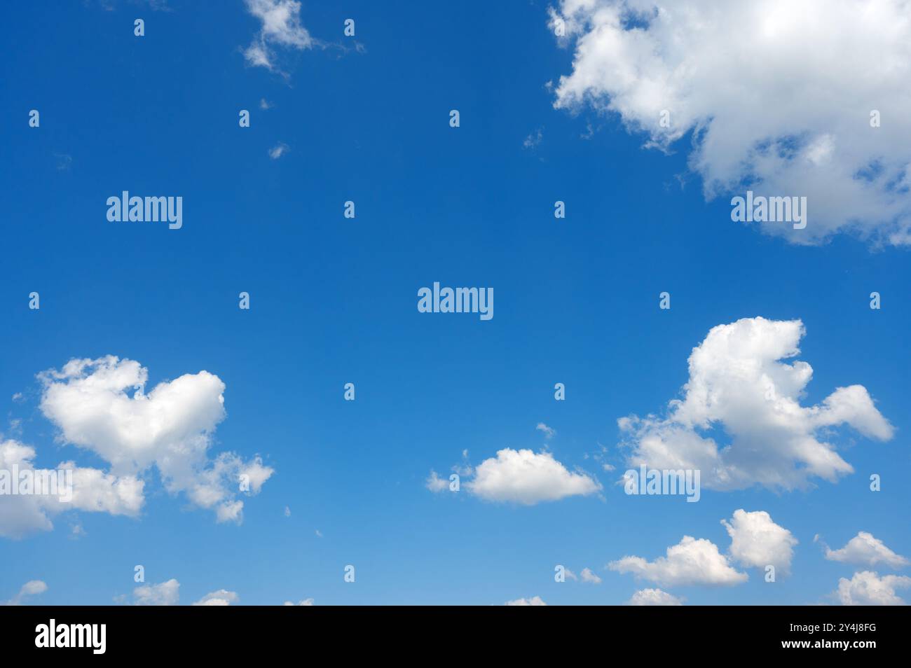 white cumulus clouds ruffled by the strong wind in the blue sky Stock Photo