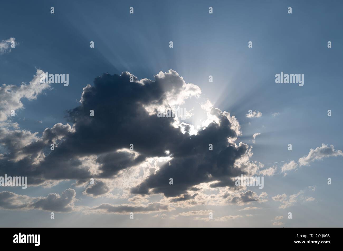 Sun behind a cloud with rays of light Stock Photo
